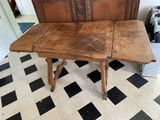 a wooden table with a wooden top on a checkered floor