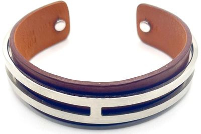 bracelet à manchette en cuir avec des rayures argentées et marron sur fond blanc