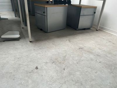 une photo d'une pièce avec deux bureaux et une chaise