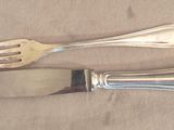 two forks and a knife sitting on a table