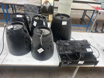 une table sur laquelle sont posés plusieurs fûts noirs