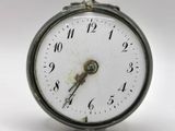 a small clock that is sitting on a white surface