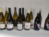 bottles of wine are lined up in a row on a white surface