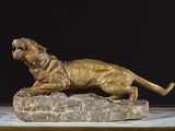 statue en bronze représentant un tigre perché sur un rocher, sur fond noir