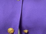 a close up of a purple jacket with gold buttons