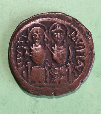 a close up of a coin on a table with a green background