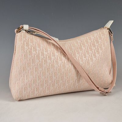 sac à main rose et blanc muni d'une bandoulière, sur fond gris