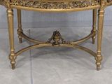 a gold table with a marble top on a tile floor
