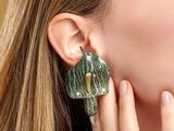 a woman that is wearing a pair of earrings