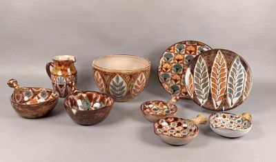 many different pieces of pottery sitting on a table