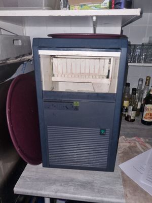 un petit réfrigérateur bleu dans un coin de la cuisine