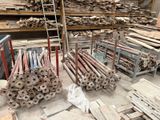 Plusieurs piles de bois sont entreposées dans un entrepôt rempli d'une grande quantité de bois