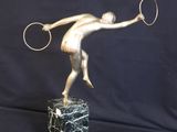 statue of a tennis player holding a racket on a marble base
