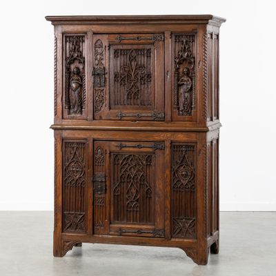 une vieille armoire en bois avec des sculptures et des gravures sur les portes