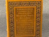 an old book sitting on top of a table on a gray surface