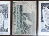 three framed pictures of a map of the world on a wall