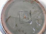 a white bowl with a brown lid on a white table