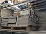 many stacks of metal and wood in a warehouse