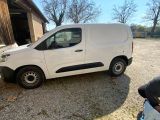 une camionnette blanche garée devant une grange