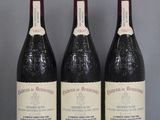 three bottles of wine sit on a glass table with a gray background
