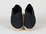 une paire d'espadrilles noires avec un logo sur la semelle
