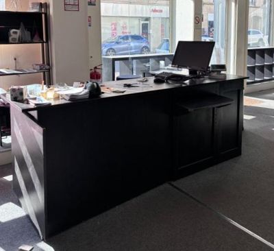 un bureau sur lequel se trouve un ordinateur, dans une grande pièce