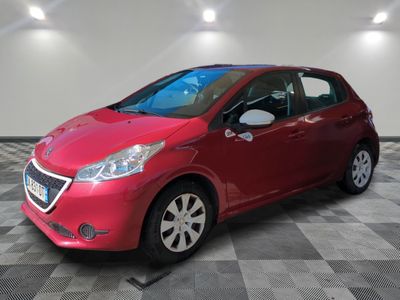 une voiture rouge est garée dans une pièce au sol en damier