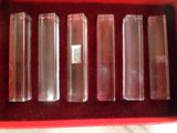 six tubes en verre transparent dans une boîte rouge posée sur une table