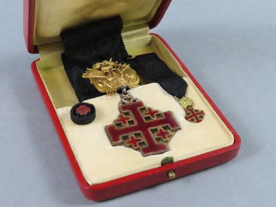 a small red box with a cross and a medal in it
