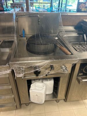 une grande cuisine en inox équipée d'une cuisinière et d'un évier
