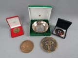 several coins and a medal are sitting on a table next to each other