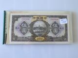 Un billet de banque chinois portant une inscription en chinois, posé sur une table