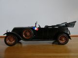 une petite voiture posée sur une table, avec un drapeau dessus