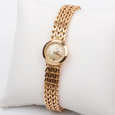 une photo d'une montre-bracelet pour femme posée sur un oreiller