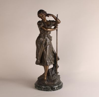 statue en bronze représentant une femme accompagnée d'un chien, posée sur un socle en marbre