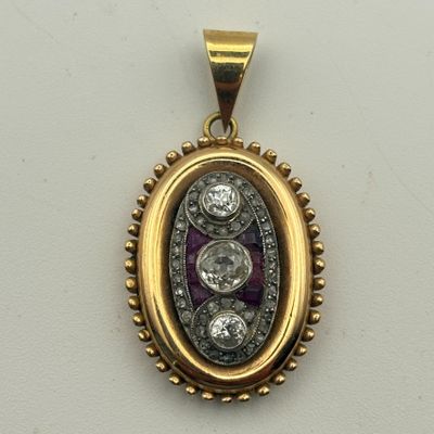 un gros plan d'un pendentif en or et diamants posé sur une surface blanche