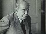 black and white photograph of a man sitting at a table with a cup of coffee