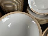 a lot of white and gold plates stacked on top of each other