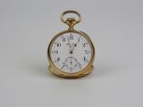 une montre de poche en or avec un cadran blanc sur une surface blanche