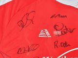 a lot of autographs on the shirt of a soccer player