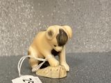 a small figurine of a dog with a tag on it