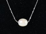 un collier de perles blanches sur une chaîne en argent