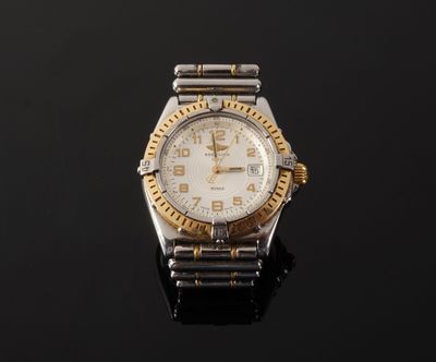 a close up of a watch on a black surface with a black background