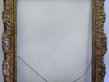 an old picture frame sitting on top of a table next to a wall