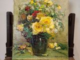 un tableau représentant des roses jaunes dans un vase posé sur un chevalet