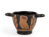 une image représentant un vase noir et orange orné d'un hibou
