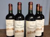 four bottles of wine are lined up on a table