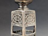 an image of a silver vase with a celtic design on the top of it