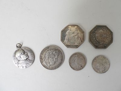 several coins are arranged in a row on a white surface