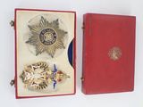 a red box with a medal and other items in it